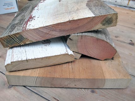 Malmtømmer hvor malmen (det rødlige trevirket i sentrum) fyller en stor del av tverrsnittet på materialet. Malmen inneholder en høy andel harpiksstoffer og bidrar til at trevirket er natur-lig gjennomimpregnert. I tillegg til de tette årringene er dette optimalt i forhold til kvaliteten på tømmeret. På dette bildet vises ulike materialer fra svalgangsbygningen. Tverrsnittet viser den eksepsjonelt gode kvaliteten på materialene som ble valgt ut til dette huset.