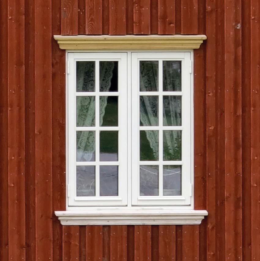 Denne masseproduserte vinduskopien har malte aluminiumsbeslag, enkle kraftige hengsler og falske sprosser. Legg merke til at lysåpningen blir endel mindre enn på originalen til venstre. Livløse glassruter og utenpåliggende kroker.